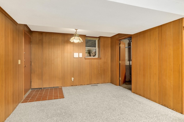 spare room featuring wood walls and carpet