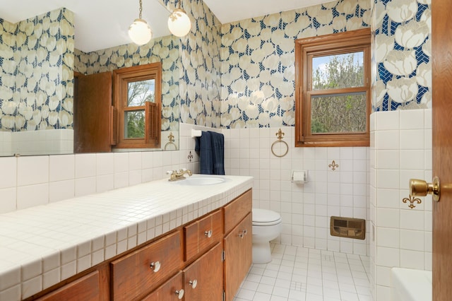 3308 Gate Rd, Saint Anthony, MN 55418 - full bath with wallpapered walls, vanity, toilet, tile patterned flooring, and tile walls