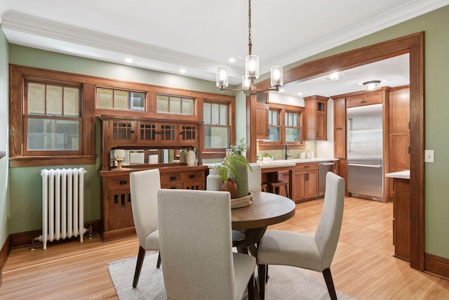 dining room with radiator heating unit, a chandelier, baseboards, crown molding, and recessed lighting