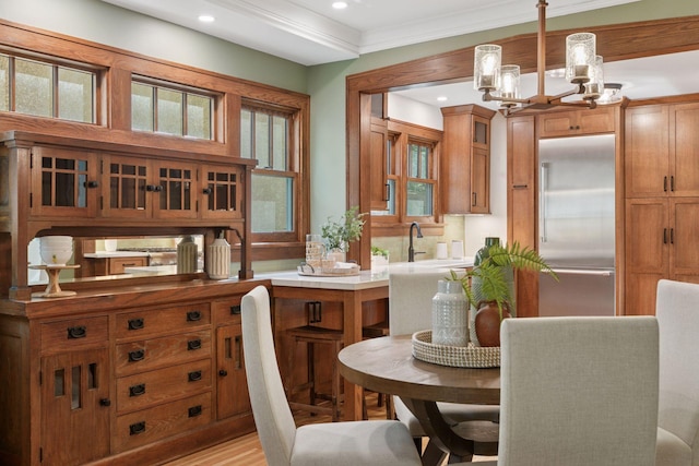 dining area featuring a chandelier, recessed lighting, ornamental molding, and light wood-style floors