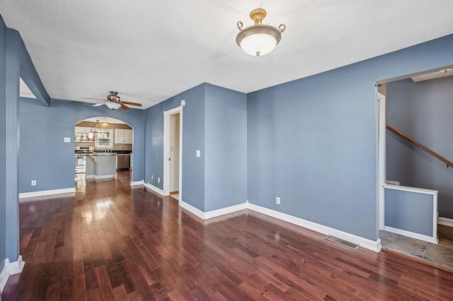 919 6th Ave S, Stillwater, MN 55082 - spare room featuring arched walkways, dark wood-style flooring, a ceiling fan, and a textured ceiling