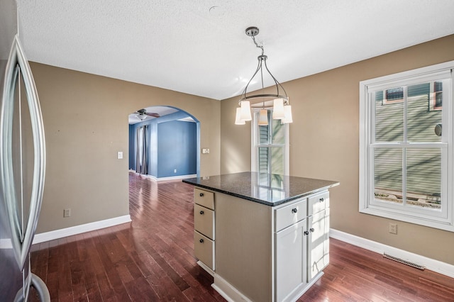 919 6th Ave S, Stillwater, MN 55082 - kitchen with dark wood-style floors, freestanding refrigerator, a kitchen island, and pendant lighting