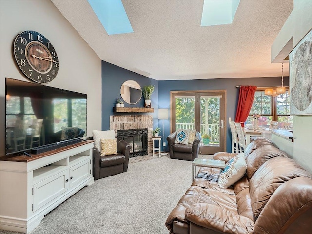 living area with carpet, a textured ceiling, a healthy amount of sunlight, and a stone fireplace