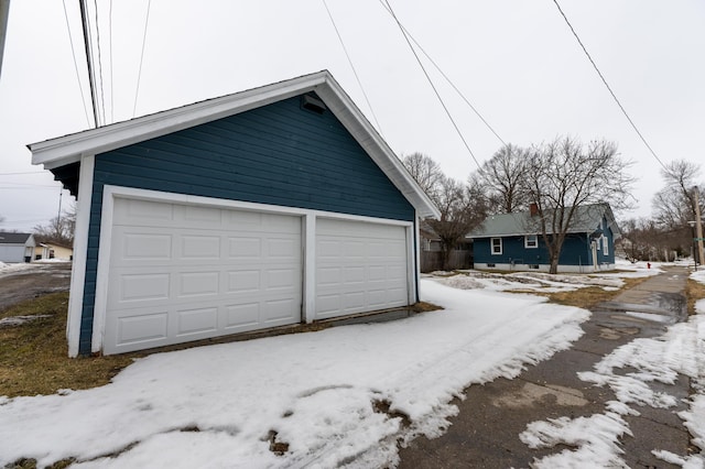 snow covered garage with a detached garage