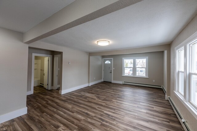 entrance foyer with dark wood-type flooring, a baseboard radiator, baseboards, and a textured ceiling