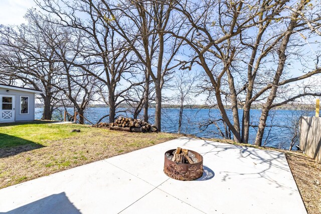 view of patio with a water view and an outdoor fire pit