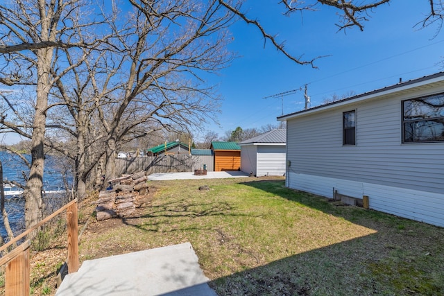 view of yard featuring fence, an outdoor structure, a patio area, and a storage shed
