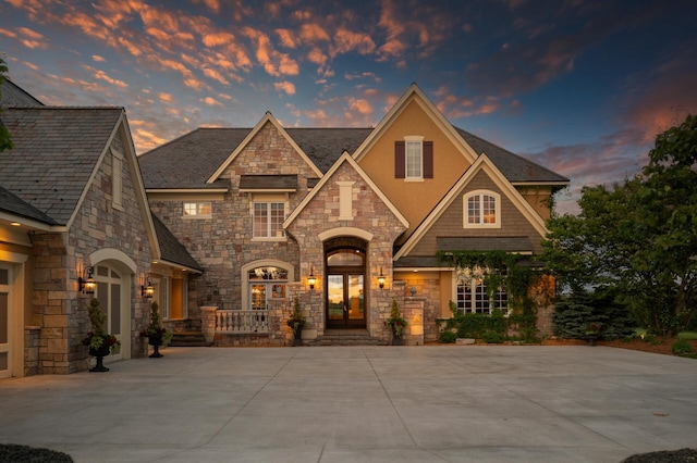 view of front of property with french doors, stone siding, and stucco siding