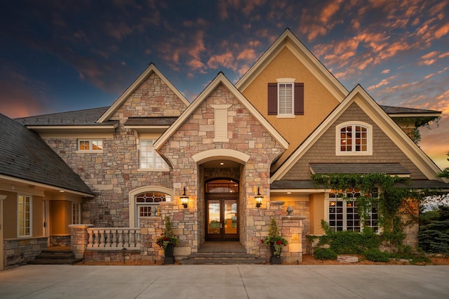 view of front of house with french doors, stucco siding, and stone siding