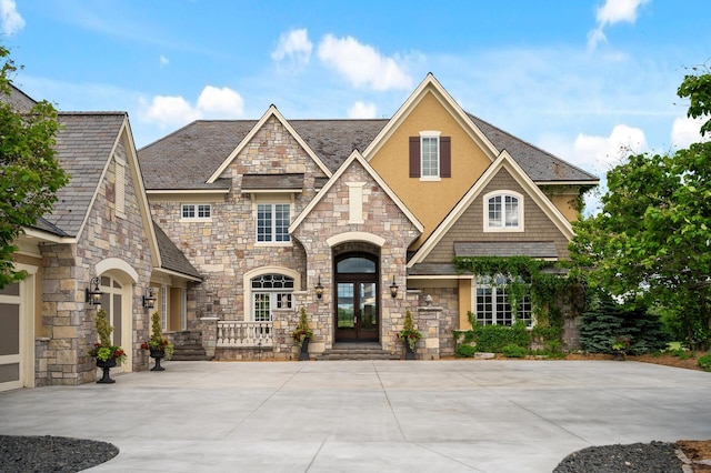 view of front of home featuring french doors, stone siding, and stucco siding