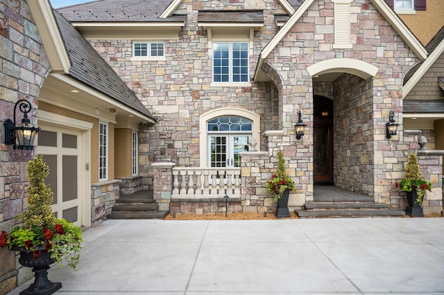 property entrance featuring a high end roof, stone siding, and a porch