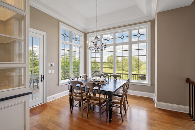 dining space featuring light wood-style flooring, baseboards, and an inviting chandelier