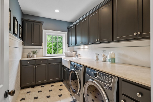 washroom with recessed lighting, a sink, washing machine and clothes dryer, and cabinet space