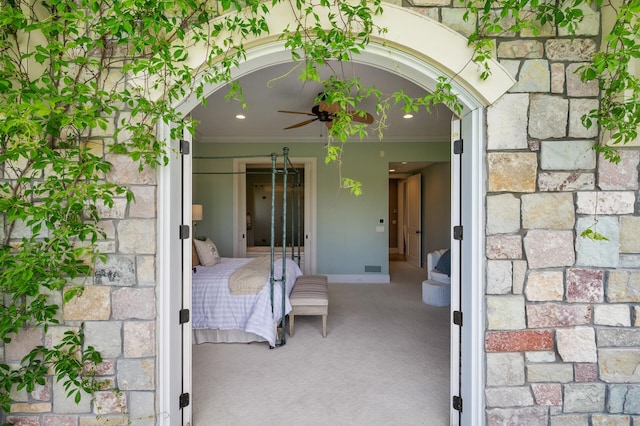 carpeted bedroom with arched walkways and crown molding