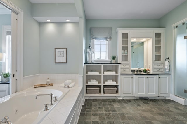bathroom featuring recessed lighting, vanity, and a tub with jets