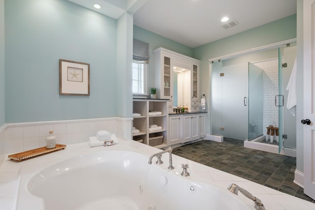 full bathroom featuring visible vents, a shower stall, a jetted tub, and vanity