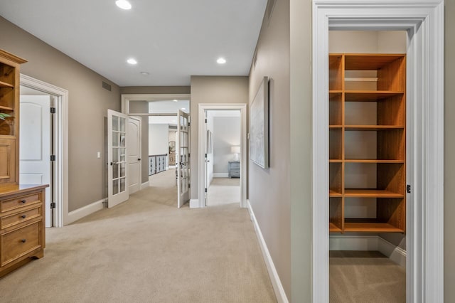 hall featuring light carpet, recessed lighting, french doors, and baseboards