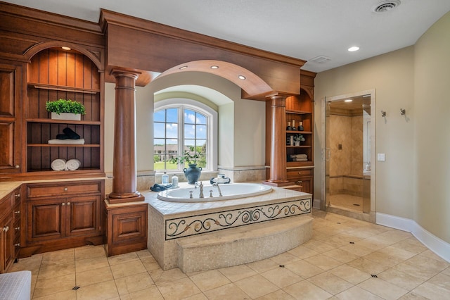 interior space with a shower stall, tile patterned floors, decorative columns, and visible vents