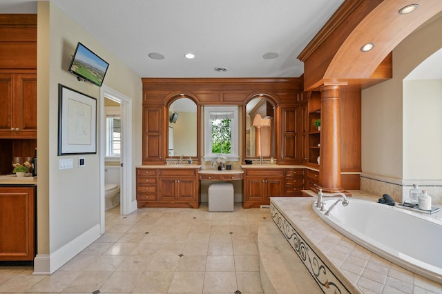 full bathroom with a bath, toilet, vanity, and a healthy amount of sunlight