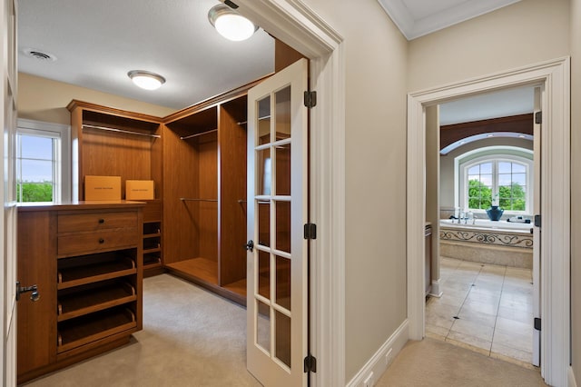 spacious closet with french doors, carpet, and visible vents
