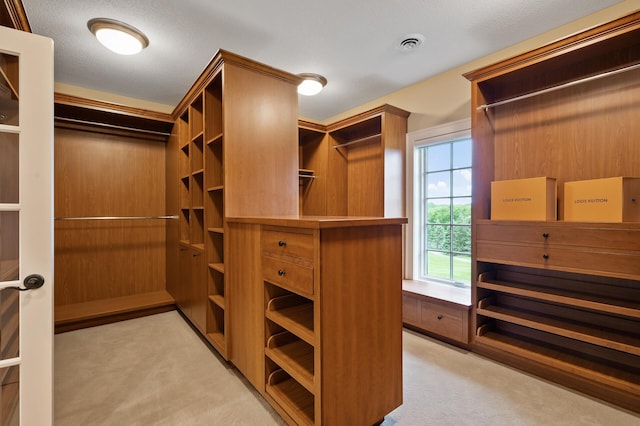 spacious closet with visible vents and light colored carpet