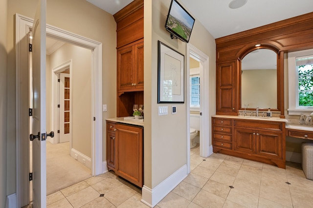 interior space with tile patterned floors, vanity, baseboards, and toilet
