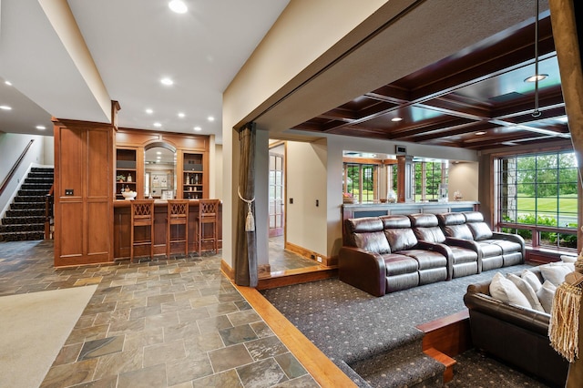 living room featuring indoor bar, baseboards, recessed lighting, stone tile floors, and stairs