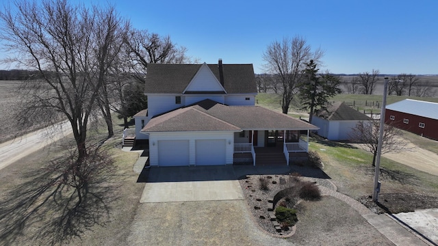 view of front facade featuring a garage, covered porch, roof with shingles, and concrete driveway