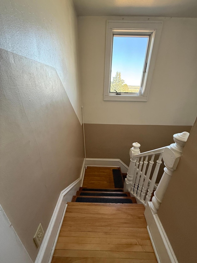 staircase with baseboards and wood finished floors