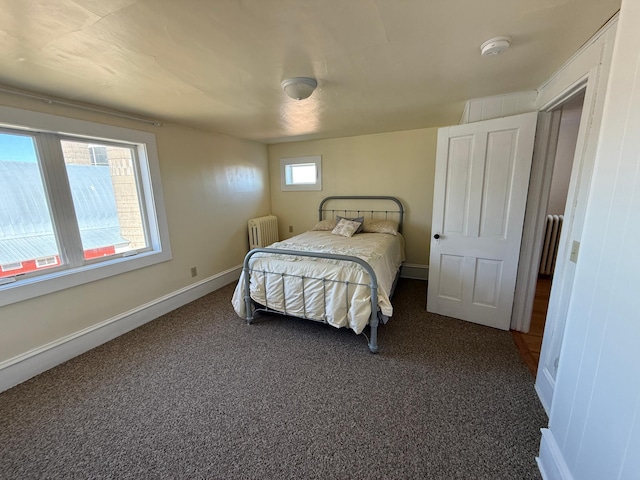 carpeted bedroom with radiator and baseboards