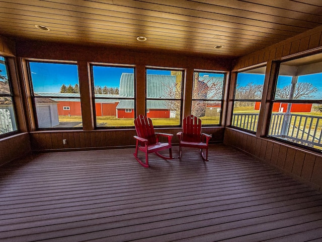 sunroom featuring carpet floors and wood walls