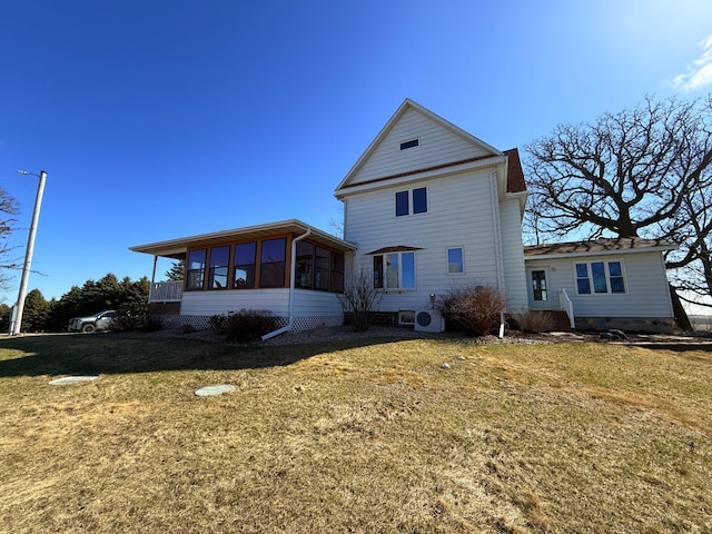 rear view of property featuring a yard and a sunroom