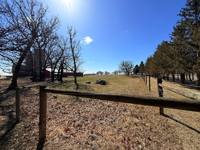 view of yard featuring a rural view and fence