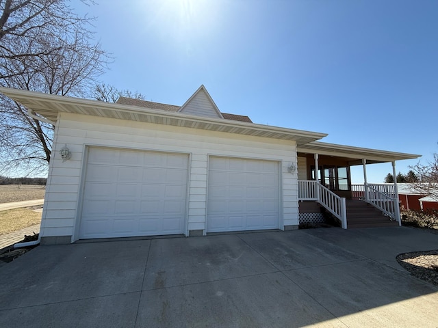 exterior space featuring driveway, covered porch, and a garage