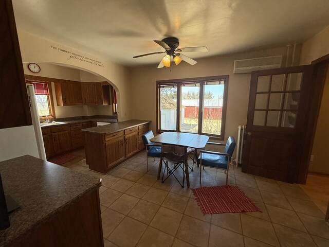 20343 680th Ave, Alden, MN 56009 - dining area with light tile patterned floors, arched walkways, and a ceiling fan