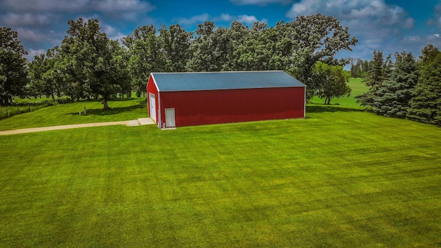 20343 680th Ave, Alden, MN 56009 - view of grassy yard with a garage, an outdoor structure, an outbuilding, driveway, and view of wooded area