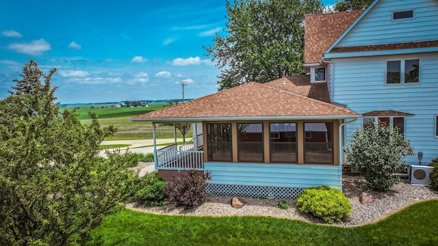 20343 680th Ave, Alden, MN 56009 - view of side of property with a shingled roof, a sunroom, and a yard