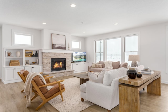 living area featuring a fireplace, recessed lighting, and light wood-style flooring