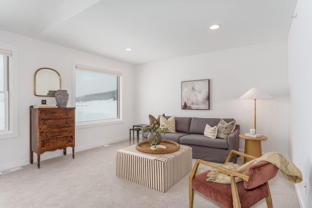 living area with visible vents, recessed lighting, baseboards, and light carpet