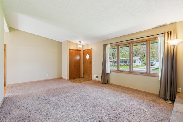 unfurnished living room featuring carpet floors, baseboards, and a textured ceiling