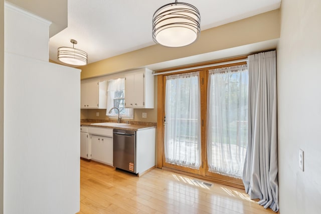 kitchen featuring stainless steel dishwasher, a sink, white cabinets, and light wood-style floors