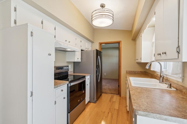 kitchen featuring appliances with stainless steel finishes, a sink, under cabinet range hood, light wood finished floors, and white cabinets