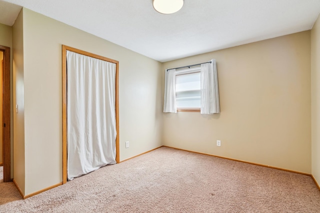 spare room with carpet floors and baseboards