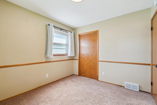 carpeted empty room featuring baseboards