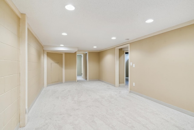 finished below grade area featuring recessed lighting, light colored carpet, and baseboards