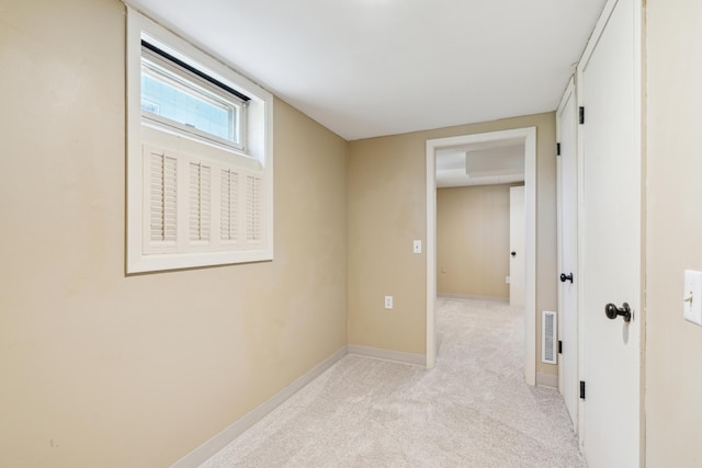unfurnished room featuring baseboards and light colored carpet