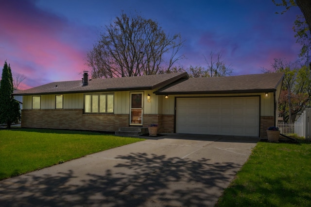 view of front of home with brick siding, concrete driveway, a garage, and a lawn
