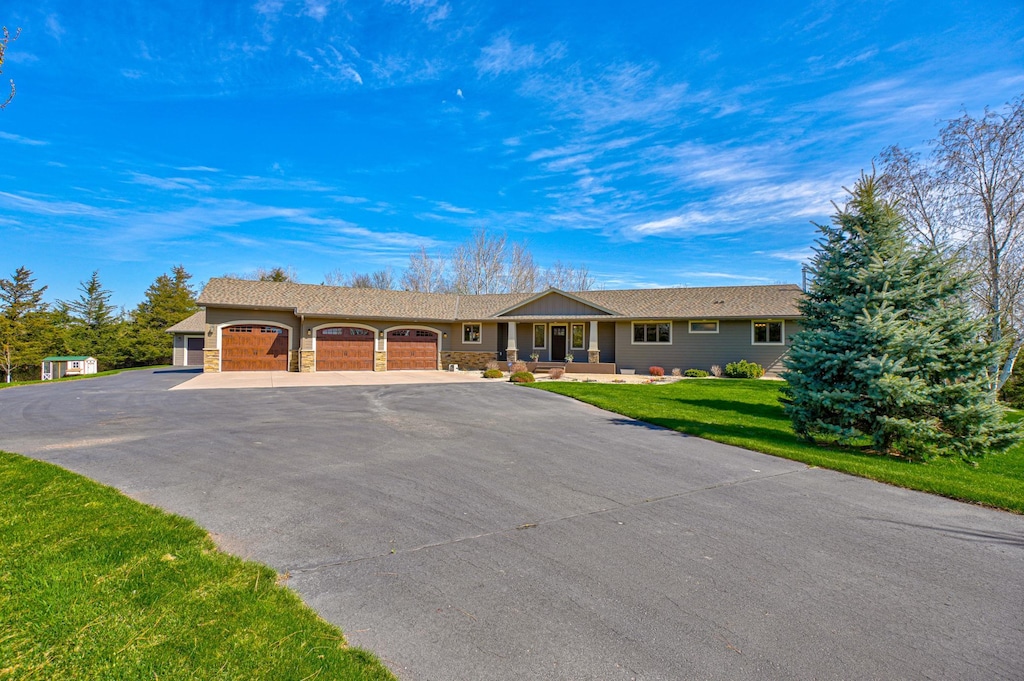 single story home featuring a front yard, aphalt driveway, and an attached garage