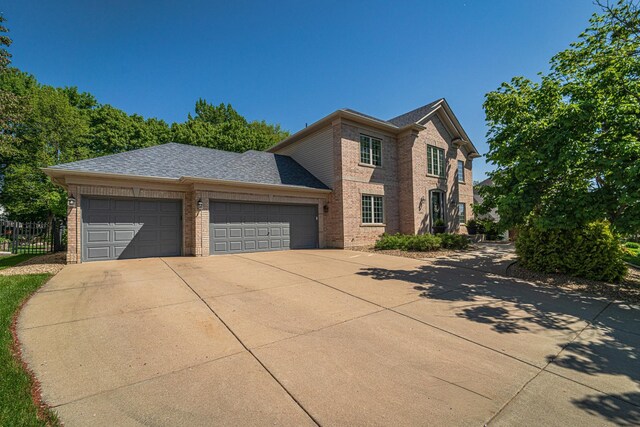 view of front facade with brick siding, an attached garage, concrete driveway, and roof with shingles