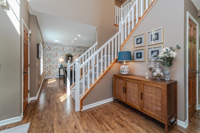 foyer entrance with stairway, baseboards, wood finished floors, recessed lighting, and wallpapered walls